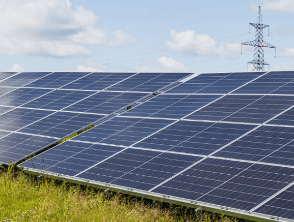 Solar panel array with transmission tower in the background
